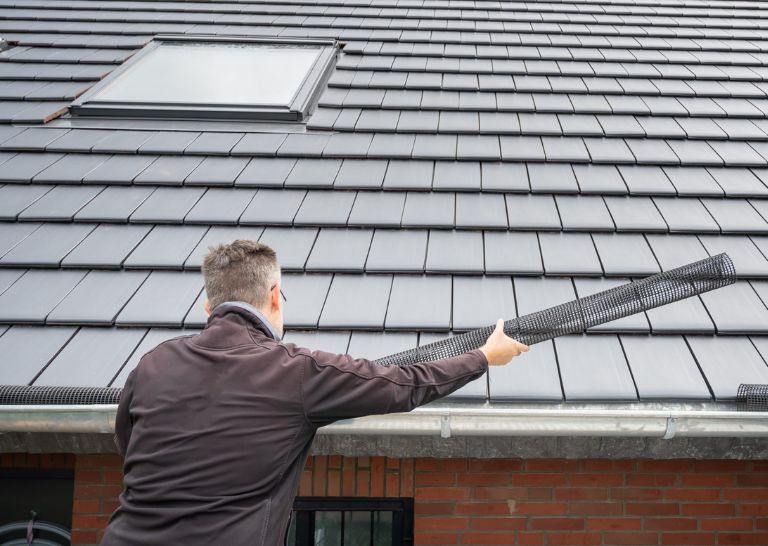 Roofing contractor installing gutter guards